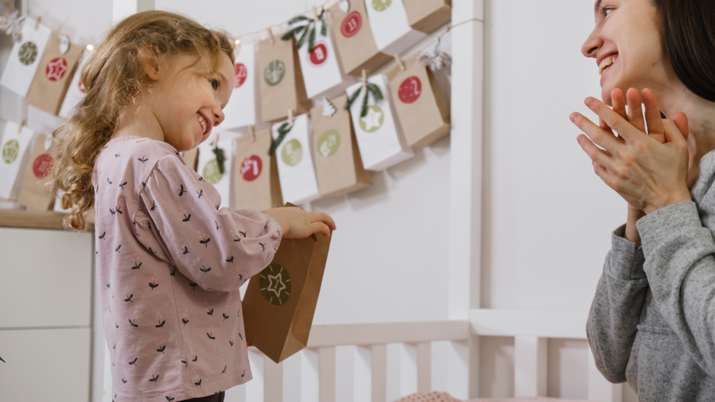 Mama i dziecko otwierają kopertę z kalendarza adwentowego DIY, ciesząc się wspólnym grudniowym rytuałem